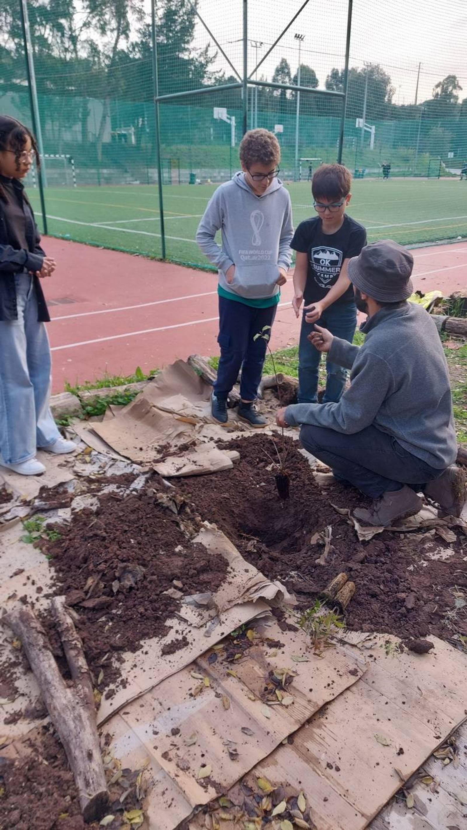 Esclarecimento de dúvidas do investigador aos alunos de como plantar as diferentes espécies.