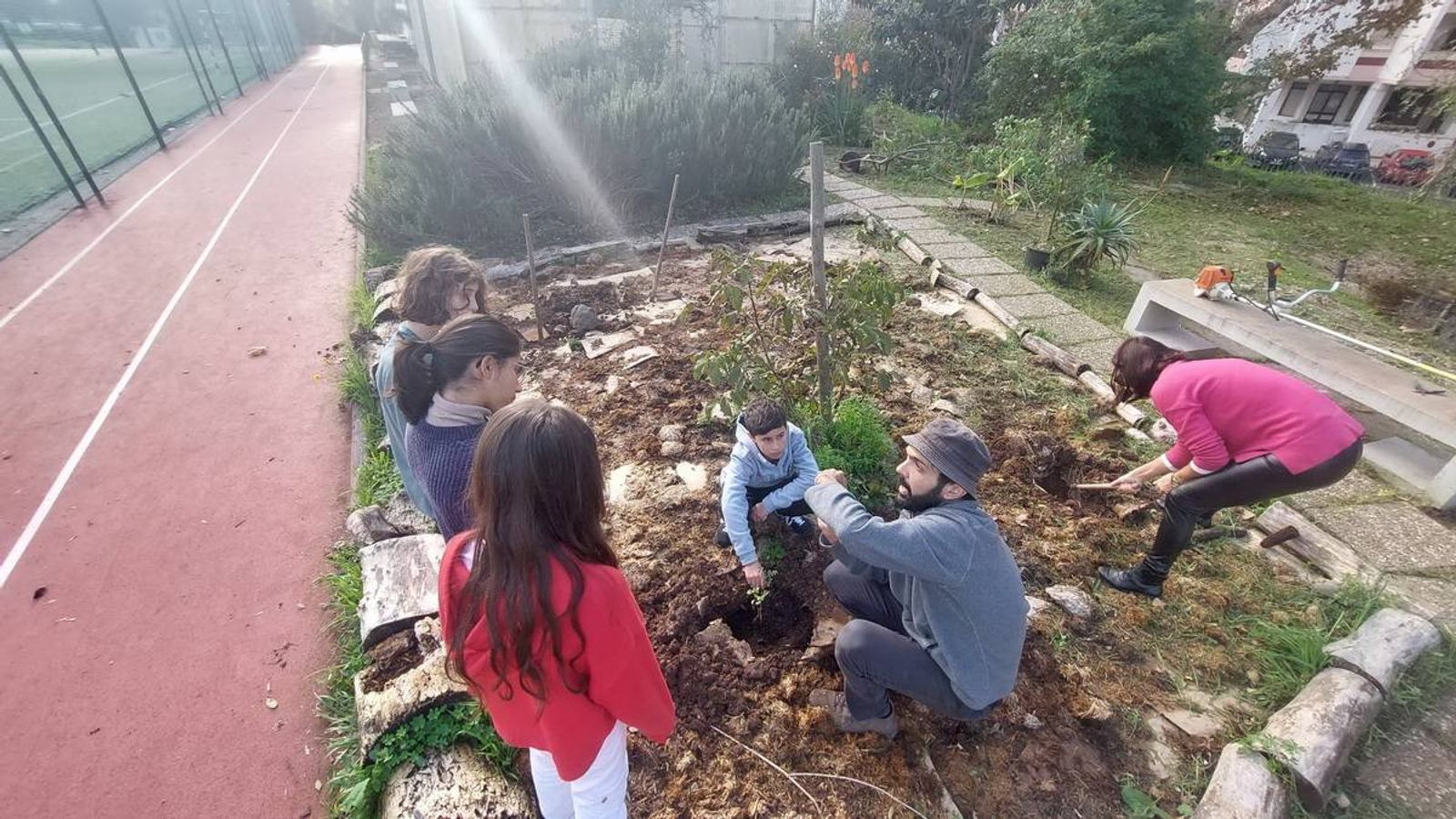 Esclarecimento de dúvidas do investigador aos alunos de como plantar as diferentes espécies.
