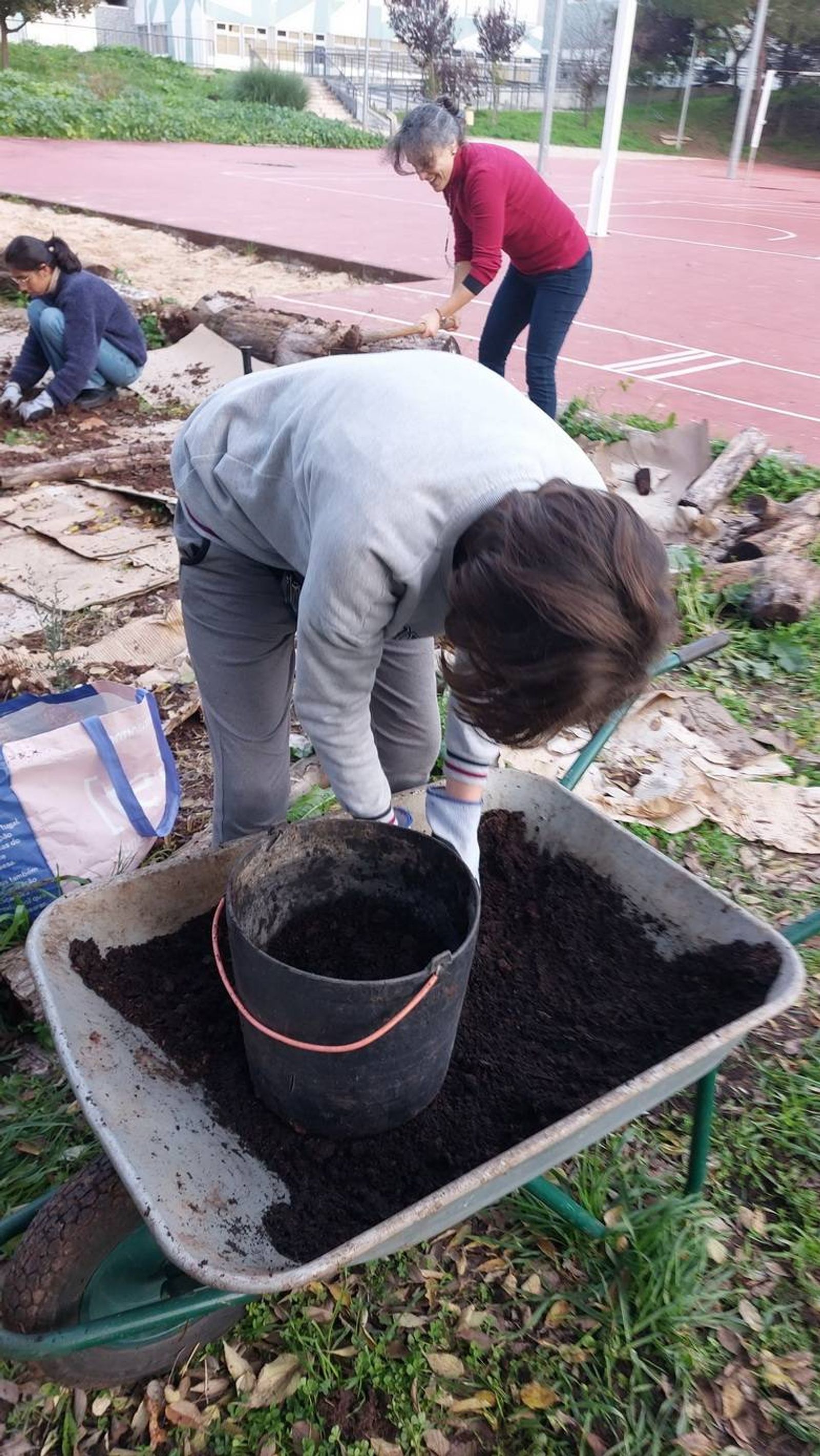 Alunos a prepararem o substrato para a plantação das espécies.